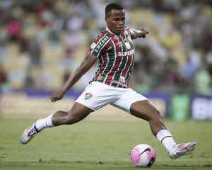 Jhon Arias, do Fluminense. Ele está chutando uma bola com o pé direito.